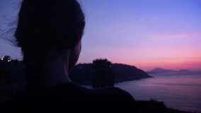Female holding mobile phone with image of sunrise on the screen taking photo