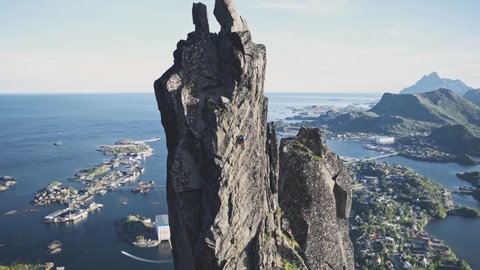 Person trad climbing on extremely dangerous rocky cliff in Norway, Svolværgeita Lofoten