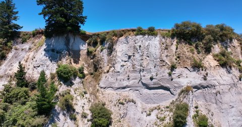 Aerial close up traverses the bright clay cliff faces of Ohingaiti - NZ