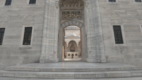 First-person view walking through entrance portal towards courtyard Süleymaniye Mosque, Istanbul in Turkey. FPV