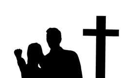Animation of silhouette of couple over clouds and cross. religion and faith concept digitally generated video.