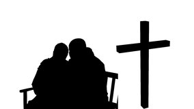 Animation of silhouette of couple over clouds and cross. religion and faith concept digitally generated video.