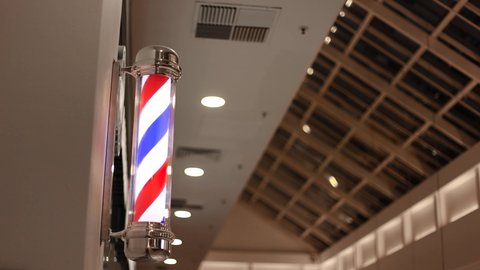Red-white-blue rotating barbershop sign close-up.