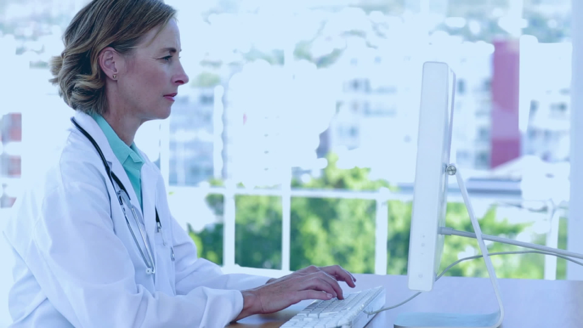 Animation of scientific data processing over caucasian female doctor using computer. medicine, technology and data processing concept digitally generated video.