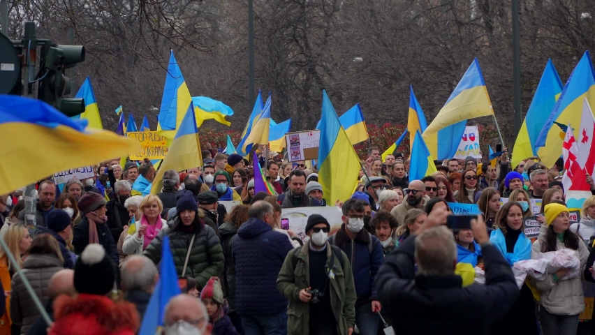 Ukrainian women and men protest on the streets of Milano against the war and against the Russian leader Putin. death and war in Ukraine. people with placards, flags Europe, Italy Milan, march 2022 