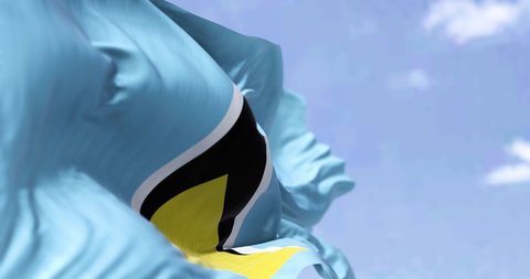 Detail of the national flag of Saint Lucia waving in the wind on a clear day. Saint Lucia is an island country in the West Indies. Selective focus. Seamless looping in slow motion