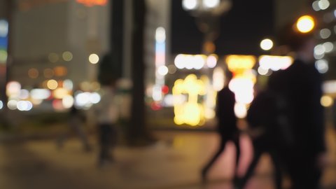 Nagoya.Japan-October 31.2019: Blurry glittering bokeh effect of the streets of Nagoya in Japan. Out of focus. Unfocused city lights. Nighttime. People walking. Metropolitan life.