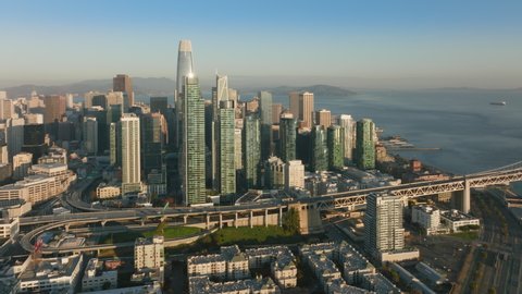 San Francisco skyline aerial 4K on early morning with cinematic golden sunrise light shining on modern glass skyscrapers. Financial District drone view. Techno capital of United States of America