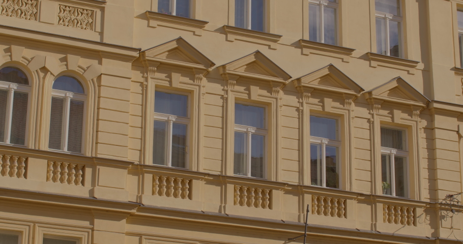 Residential Establishment Tips Facade of the building with windows of the old district of city. Making a pattern on wall, attracting attention. Yellow house decoration. Residential Accommodation Guide