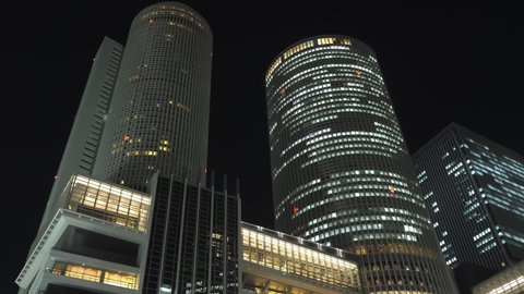 Nagoya.Japan-October 31.2019: Skyscrapers in the downtown of Nagoya in Japan. Busy metropolitan life concept. Nighttime. Beautiful cityscape. Camera turning right while slightly tilting downwards.