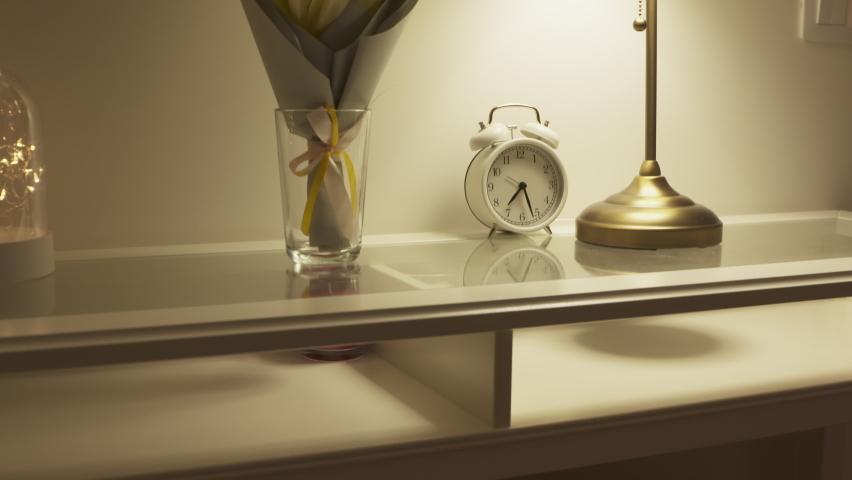 Console table with bouquet of flowers lit by a table lamp in the living room, apartment decoration background. High quality 4k footage