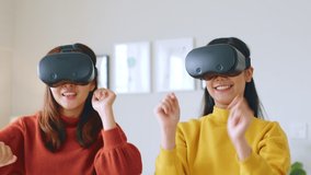 Young Asian woman dancing while using 360 VR headset for virtual reality, metaverse at home