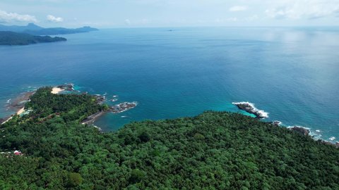 Aerial view overlooking the Ilheu das Rolas island, in sunny Sao Tome and Principe - reverse, drone shot