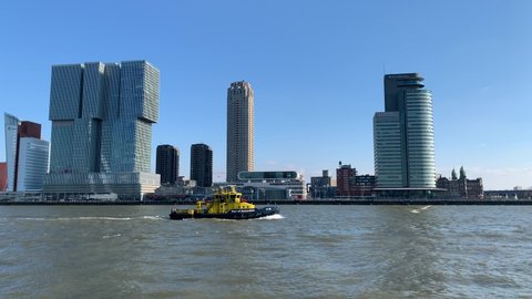 Rotterdam, South Holland, Netherlands - March 6, 2022: Port of Rotterdam authority boat, ship is going through New Meuse (Nieuwe Maas) river at the city centre. Skyline of Rotterdam in the background