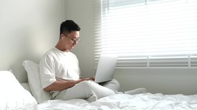A moment of young men stretch out and when working with laptop in white bed for advertising