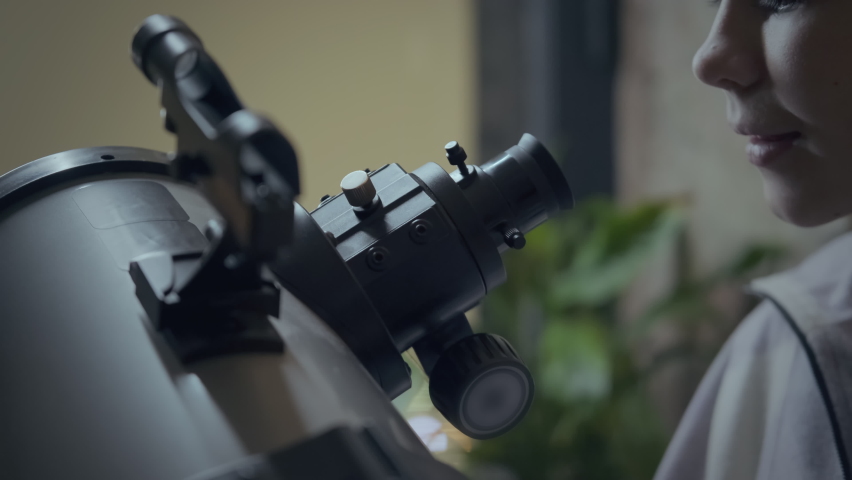 Close-up of Caucasian girl enjoying learning astronomy watching stars and planets using telescope