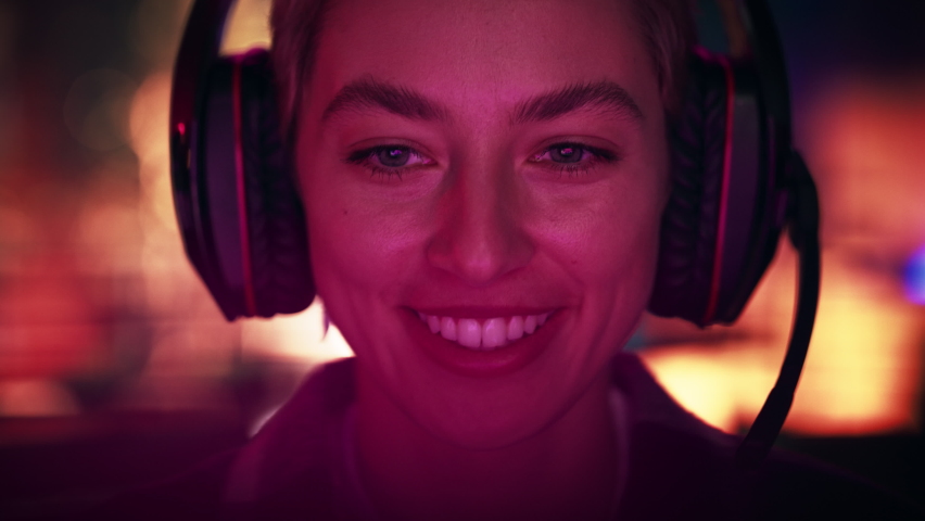 Close Up Portrait of a Stylish Young Female with Short Hair Playing Online Computer Video Game in the Evening at Home. Gamer Discussing Tactics with Teammates while Talking into Headset. Royalty-Free Stock Footage #1088539533