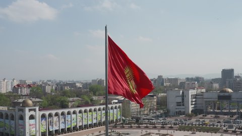 Bushkek, Kyrgyzstan - April 3, 2020: Aerial drone footage of monument of riding knight in centre of Bishkek at Ala-too square in Kyrgyzstan and red national flag waving. Travel, explore central Asia. 
