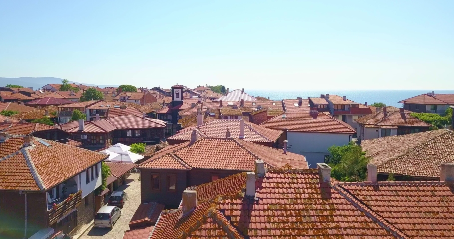 Aerial drone view of Nesebar old town, Bulgaria. Red tiled roofs of houses and a lot of seagulls are fly