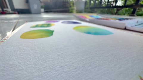 Time lapse applying magenta purple and granulating cerulean blue watercolour pigment on wet cotton paper. Macro footage of practicing watercolor exercises.