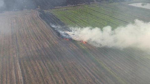 Aerial footage of this burning farmland getting ready for planting but contributes to air pollution, Grassland Burning, Pak Pli, Nakhon Nayok, Thailand.