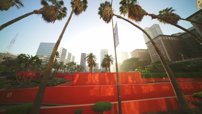 LOS ANGELES, CA, USA - March 15, 2022: Sunset, palm trees, Downtown Los Angeles. Slow motion drone shot. historical center of LA. Concept of urban life commute, travel destination in America.
