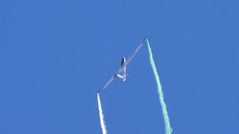 Thiene Italy OCTOBER, 16, 2021 Extreme aerobatics maneuvers by Swift-S1 aerobatics glider. Hammerhead. Smoke trails against the clear blue sky. Air show for an audience. 