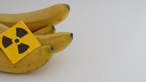 A bunch of bananas with a radiation warning sign on them. Close up.