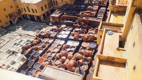 Top view of tannery with men working in the color paint for leather in Fes, Morocco.