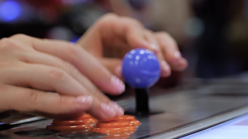 Close up view: woman hands playing retro arcade machine game and pushing orange buttons - selective focus. Gaming, 80s, hobby, vintage, technology, retro video game and leisure time concept Royalty-Free Stock Footage #1088556119