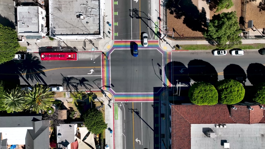 Cars more through an intersection that is painted with the colors of the LBGTQ Rainbow Pride Flag in Long Beach, California. 