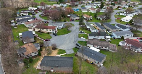 Wide angle aerial of mobile home trailer park. No leaves on trees. Winter view. Establishing shot.