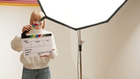 Young woman actress using movie clapper board audition