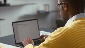 Young man typing on laptop from home office. Attractive man typing message - Powered by Shutterstock - Get 15% off with code: PIKWIZARD15