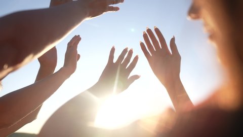 group of cheerful people together party pulling hands to the sun on the beach. teamwork. fun silhouette people party dancing recreation holiday. people music. pull their hands up. religion concept