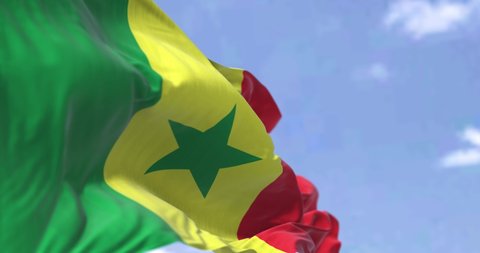 Detail of the national flag of Senegal waving in the wind on a clear day. Senegal is a country in West Africa. Selective focus. Seamless looping in slow motion