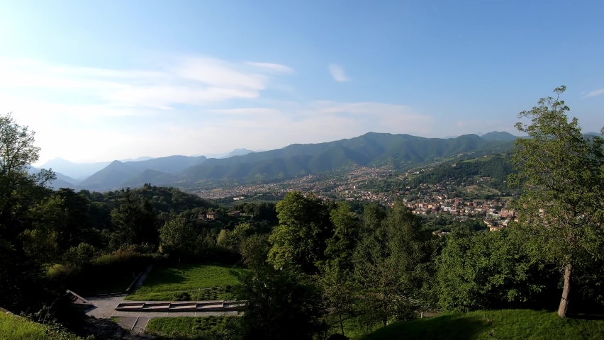 View from the Bergamo Funicular railway on the Bergamasque Alps in Lombardia, Italy, Europe. The city of Bergamo can be seen. Hills overgrown with grass and bush. Hiking trail. Travel destination
