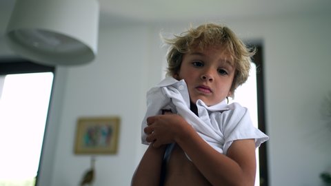 Small boy putting shirt on child clothing kid dressing himself