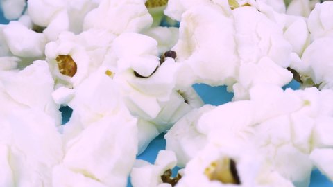 Macro shot of popcorn on blue surface, close up view in 4k.