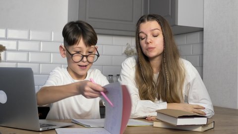 The boy does his homework and shows the results to his older sister. The girl does not willingly agree to help her younger brother. Study