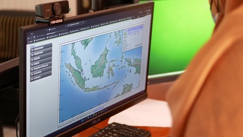 Tarakan, Indonesia. 03-25-2022. Indonesians Weatherologist were monitor radar displays. Weather forecast in a office.