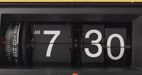 Retro Flip Clock Showing at 7:30 a.m. Spinning on black background.