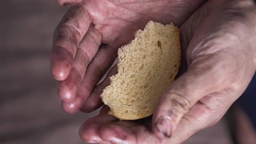 piece of bread in dirty hands of homeless poor man. humanitarian crisis concept, economic recession, unemployment, poverty, hunger, armed conflicts, epidemics, famine, malnutrition, starvation Royalty-Free Stock Footage #1088583223