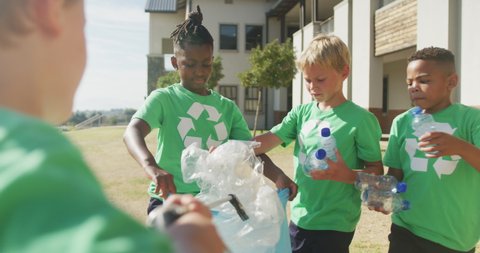 Video of diverse boys picking up trashes in front of school. primary school education, sport and exercising.