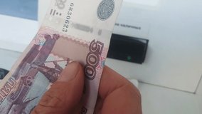 Man Inserts Cash. Currency In Russian Roubles Into The Hole Accepting Banknotes In ATM. An English Translation Of Non-English Text Is Cash In - Powered by Shutterstock - Get 15% off with code: PIKWIZARD15