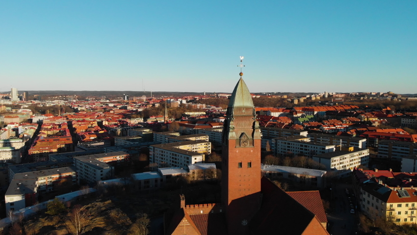 Close up Aerial establishing shot of Masthugget Church Lutheran church in Gothenburg, Sweden. Place of worship with clock tower cross. Landmark Masthuggskyrkan temple on hill with nordic architecture Royalty-Free Stock Footage #1088591761