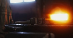 The hammer lies on the anvil in the blacksmith's workshop, close-up, no people. Details of the working process of forging iron. 4k video, red komodo