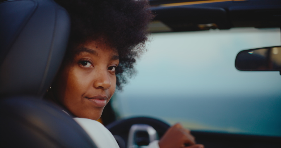 Portrait of beautiful young black african american woman smiling in her car on epic road trip, travel and adventure nomadic lifestyle | Shutterstock HD Video #1088594867