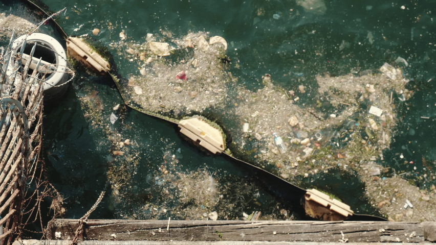Environmental pollution concept. Top view lots of plastic waste float in dirty sea water, person taking it out with net. | Shutterstock HD Video #1088601265