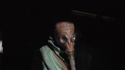 Middle aged male worker wearing gas mask for radioactive accident liquidation
